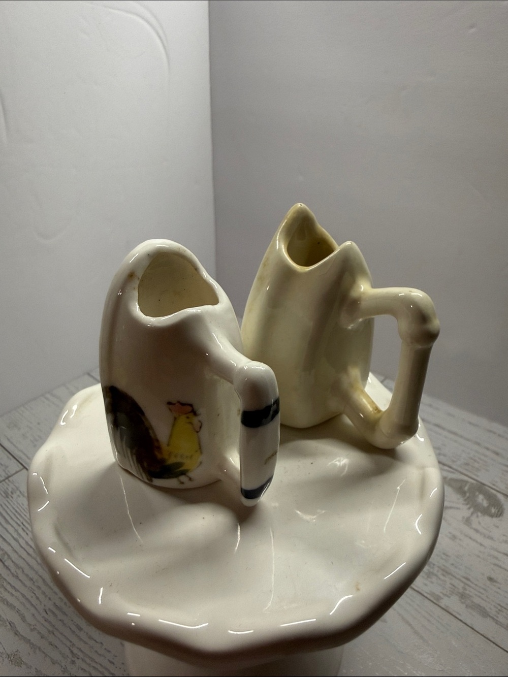 Ceramic Cream iron pitchers. One with a chicken and one with a flower.